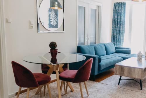 sala de estar con sofá azul, mesa y sillas en BEST HOUSE, KAPODISTRIOU, PSILA ALONIA en Patras
