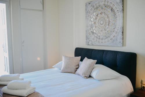 1 cama con almohadas blancas y cabecero azul en BEST HOUSE, KAPODISTRIOU, PSILA ALONIA en Patras