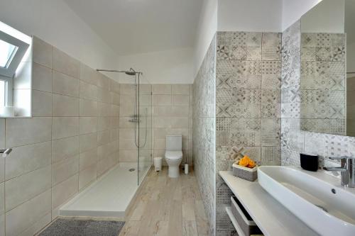 Un baño con ducha, lavabo e inodoro. en Apartamentos Tucha, en Albufeira