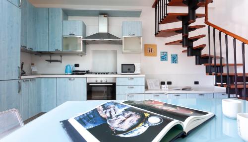 una cucina con armadi blu e un tavolo con una rivista di Italianway - Baiamonti 1 a Milano