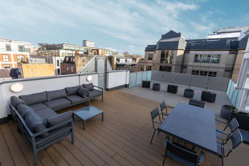 - Balcón con sofá y mesa en un edificio en JOIVY Luxury 2 bed flats with terraces near Piccadilly Circus, en Londres