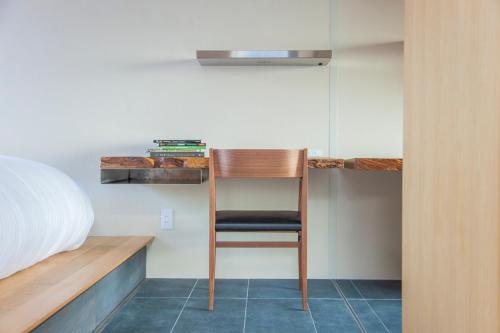 a room with a chair in a bedroom at modern ryokan kishi-ke in Kamakura