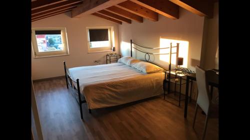 1 dormitorio con 1 cama, 1 mesa y 2 ventanas en Via Venezia Accomodating Solutions, en Lonigo