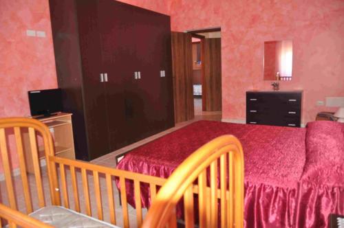 1 dormitorio con cama, vestidor y cuna en B&B Il Gabbiano, en SantʼAntìoco