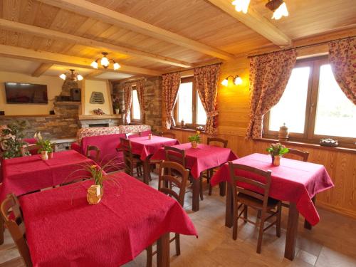 シャンポルクにあるVilla Americana Chambres d'Hotesの赤いテーブルと椅子、窓のあるレストラン