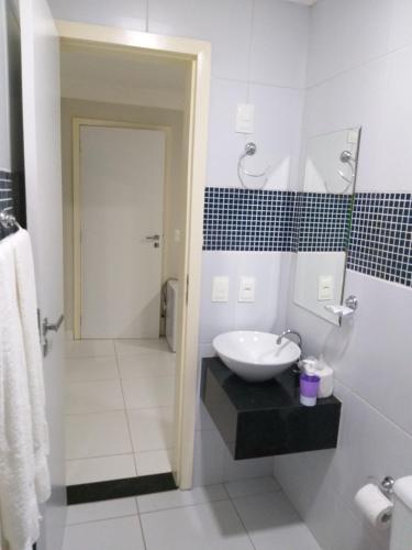 a white bathroom with a sink and a shower at Hotel Executivo Boulevard in Mossoró