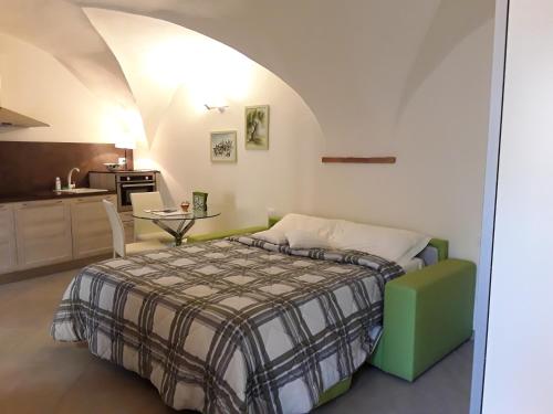 a bedroom with a bed and a kitchen at Ca' due Olivi in Toscolano Maderno