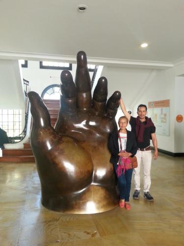 un hombre y una mujer parados junto a una gran estatua de mano en A Bogota On Holidays by Open - HOTEL, en Bogotá