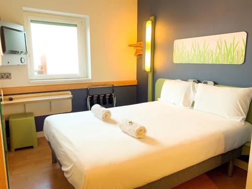 a bedroom with a bed with two wooden logs on it at ibis budget Belfast City Centre in Belfast