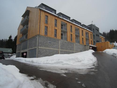 a building with a pile of snow in front of it at Hotel U Kabinky in Janske Lazne