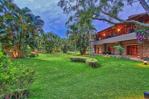 a house with a green yard in front of it at Angsana Oasis Spa & Resort in Yelahanka