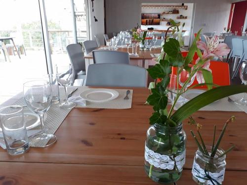 a wooden table with a vase with flowers in it at Las Eduardas in La Paloma