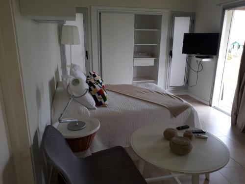 a bedroom with a bed and a table and a lamp at Las Eduardas in La Paloma