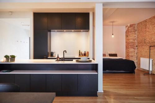 een keuken met een wastafel en een bed in een kamer bij Søndergade - “strøget” in Aarhus