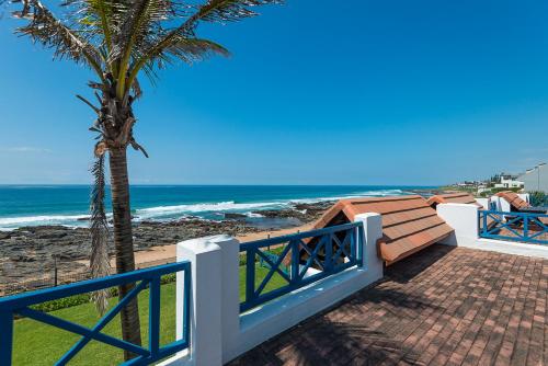 un percorso per la spiaggia con una palma e l'oceano di Le Paradis 16 a Ballito