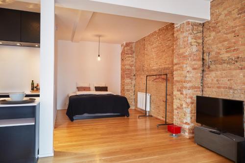 a bedroom with a bed and a brick wall at Søndergade - “strøget” in Aarhus