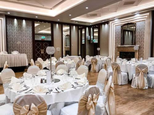 a banquet hall with white tables and chairs with bows at Dunadry Hotel And Gardens in Antrim