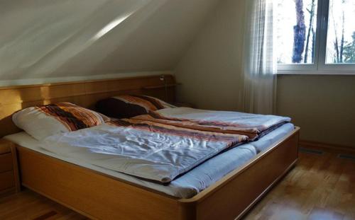- un petit lit dans une chambre avec fenêtre dans l'établissement Ferienwohnung Kiefernblick-Wedemann, à Bispingen