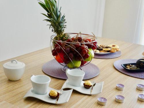 een tafel met een kom fruit en borden met voedsel bij Rainbow 1 Holiday Complex in Sunny Beach