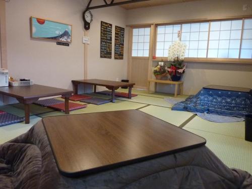 a room with tables and mats on the floor at Guesthouse Arakura in Fujiyoshida