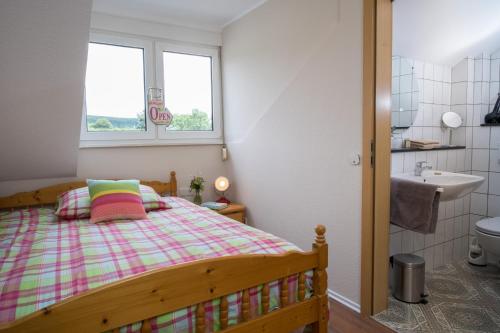 ein Schlafzimmer mit einem Bett, einem Waschbecken und einem Fenster in der Unterkunft Landhotel Eifellust in Schalkenmehren