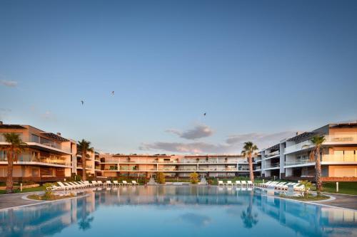 a large swimming pool in front of a hotel at Praia do Sal Resort in Alcochete