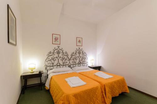 a bedroom with a bed with an orange blanket at Hotel Rex in Florence