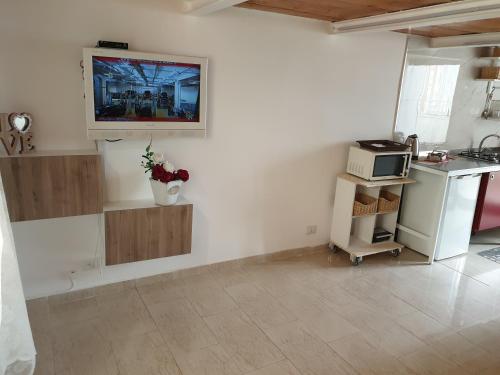 eine Küche mit einer weißen Wand mit einer Theke und einer Mikrowelle in der Unterkunft La Maison di Tiziana in Neapel