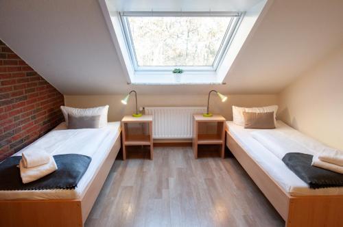two beds in a room with a window at campushus in Sankt Peter-Ording
