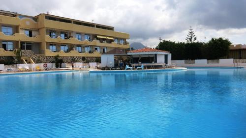 a large swimming pool in front of a hotel at Holiday apartment Paraiso in Playa Paraiso