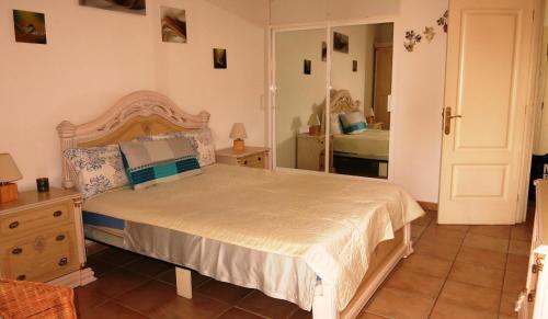 a bedroom with a large bed and a mirror at Holiday apartment Paraiso in Playa Paraiso