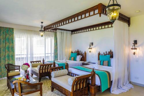 Un pat sau paturi într-o cameră la Royal Zanzibar Beach Resort