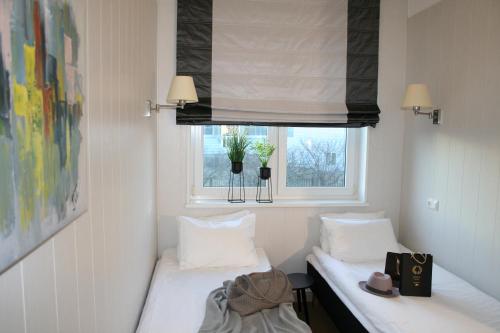 two beds in a room with a window at Sadama street Villa in Pärnu