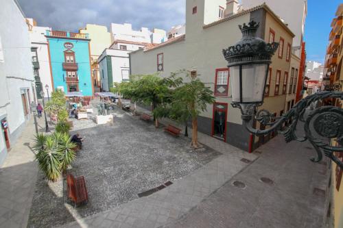 a street with buildings and palm trees and a street light at Hotel Emblemático Holiday Time in Santa Cruz de la Palma