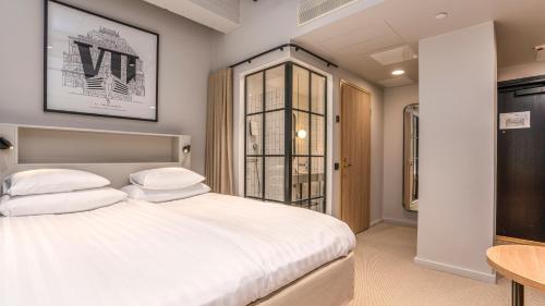 1 dormitorio con cama blanca y mesa en Original Sokos Hotel Wiklund, en Turku