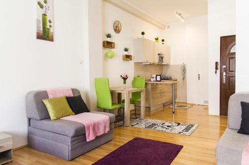 sala de estar con sofá, mesa y cocina en Andy's Home Central Apatment, en Budapest