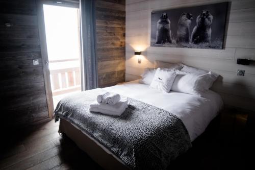 1 dormitorio con 1 cama con 2 toallas en Chalet Aguila - Jacuzzi et sauna panoramique - Construit en 2023, en Bolquere Pyrenees 2000