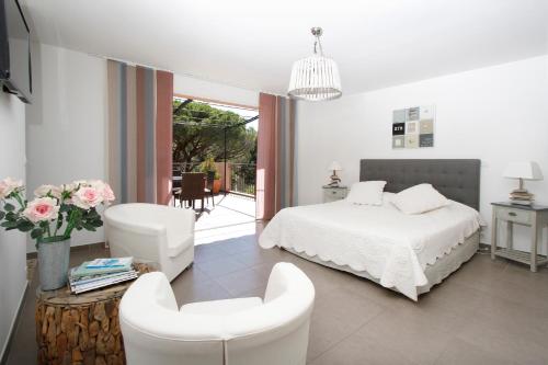 サント・マキシムにあるLe Mas du Soleilのベッドルーム1室(ベッド1台、白い椅子2脚付)