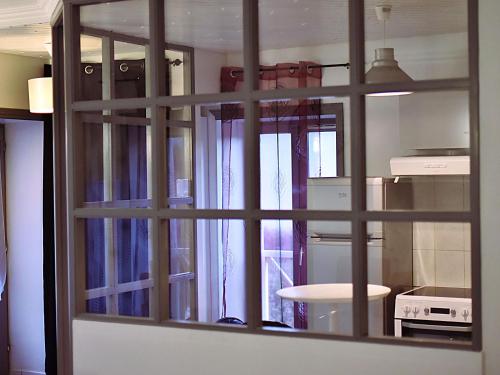a view of a kitchen through a glass window at A deux pas du Rhone in Sault-Brénaz
