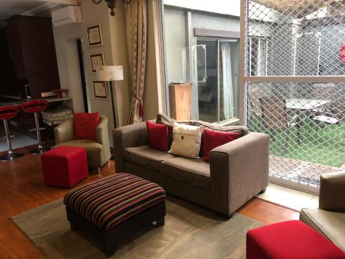 a living room with a couch and chairs and a window at 314 on Clark Guest House in Pretoria