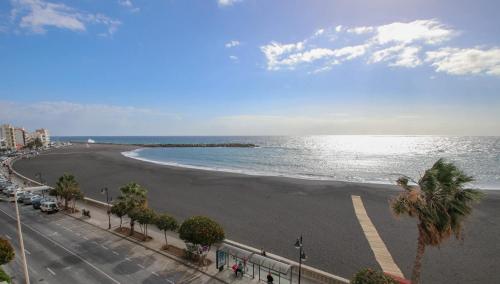 a view of a beach with palm trees and the ocean at Hotel Emblemático Holiday Time in Santa Cruz de la Palma