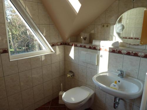 ツィングストにあるVilla Karolineのバスルーム(洗面台、トイレ付)、窓が備わります。