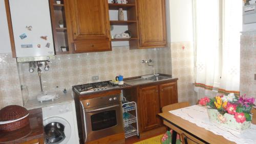 una cucina con piano cottura forno superiore accanto a un lavandino di PRIONE70 a La Spezia