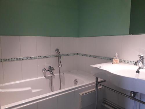 a bathroom with a bath tub and a sink at AMBIANCES chambres d 'hôtes in Baye