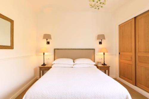 a bedroom with a large white bed with two night stands at Hôtel Les Mouettes - Teritoria in Ajaccio