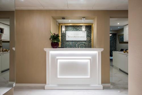 a white counter in a lobby with a sign on the wall at Residenza Venti Settembre in Rome