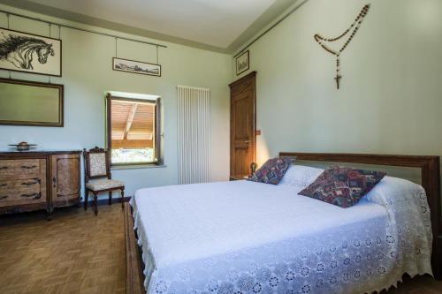 a bedroom with a bed and a chair in it at Cascina Tetto del Priore in Cuneo