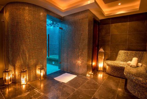 a bathroom with a shower with lights and a chair at Loughrea Hotel & Spa in Loughrea