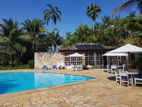 a resort with a swimming pool with chairs and umbrellas at Villas De Paraty in Paraty