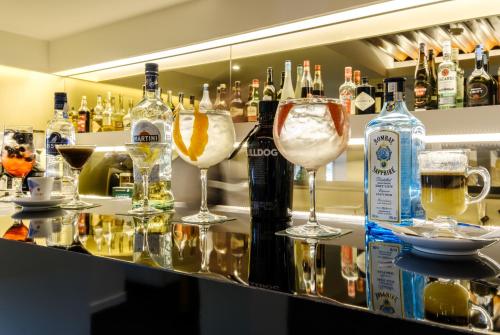 a bar with two wine glasses and bottles of alcohol at Hotel Regina in Fátima